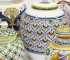 Vasi e lampade in ceramica siciliana dipinta a mano con motivi tradizionali blu, gialli e verdi.